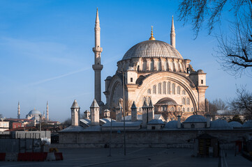 Obraz premium The Gazi Atik Ali Pasha Mosque in Istanbul stands against a clear blue morning sky, highlighting its domes and elegant Ottoman architecture.