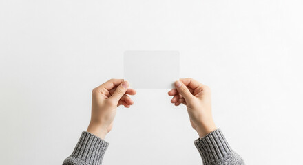 Obraz premium Hands Holding Blank White Card Against Clean Background