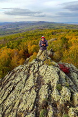 Tourists on the rock of the peak of KorotashBao on the Irendyk ridge in the Southern Urals on an autumn evening