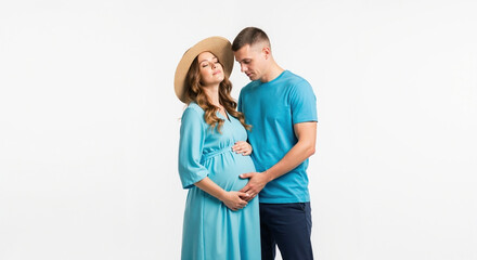 Pregnant woman with partner in matching turquoise outfits and hat studio portrait. Stylish maternity session for prenatal care and pregnancy announcement services