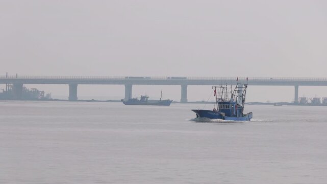 Fshing boat heading out to sea from the coastal port in Binhai, Tianjin, China.p