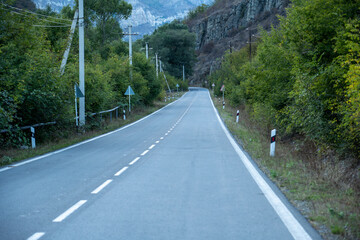 Curvy mountain road surrounded by green forest and dramatic cliffs