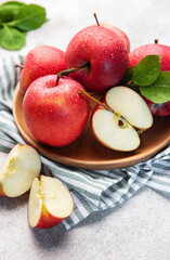 Healthy red apples with water drops on wooden plate