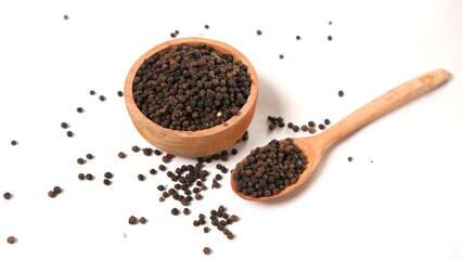 Black Peppercorns in Wooden Bowl and Spoon on White Surface