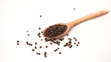 Black Peppercorns in Wooden Spoon on White