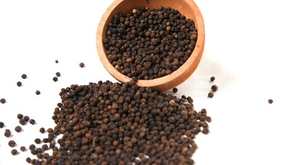 Black Peppercorns Spilling from Wooden Bowl on White Background