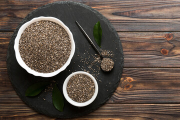 Chia seeds in bowl and spoon on colored background. Healthy Salvia hispanica in small bowl. Healthy superfood