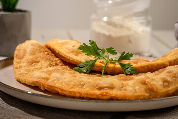 Traditional chebureki with crispy crust and parsley