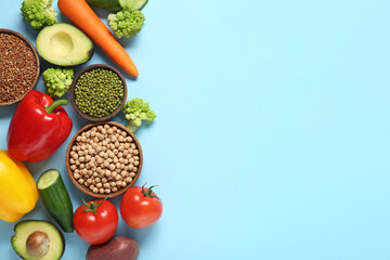 Different fresh vegetables with buckwheat and legumes on blue background. World Vegan Day