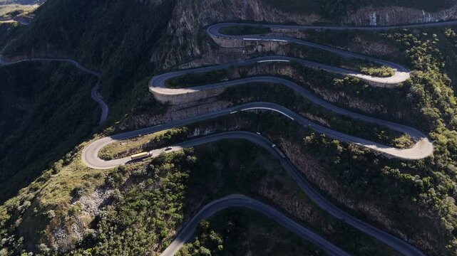 aerial of Leba Pass, Angola, ars driving along the twisting road of Leba Pass in southern Angola, surrounded by majestic mountain landscapes.