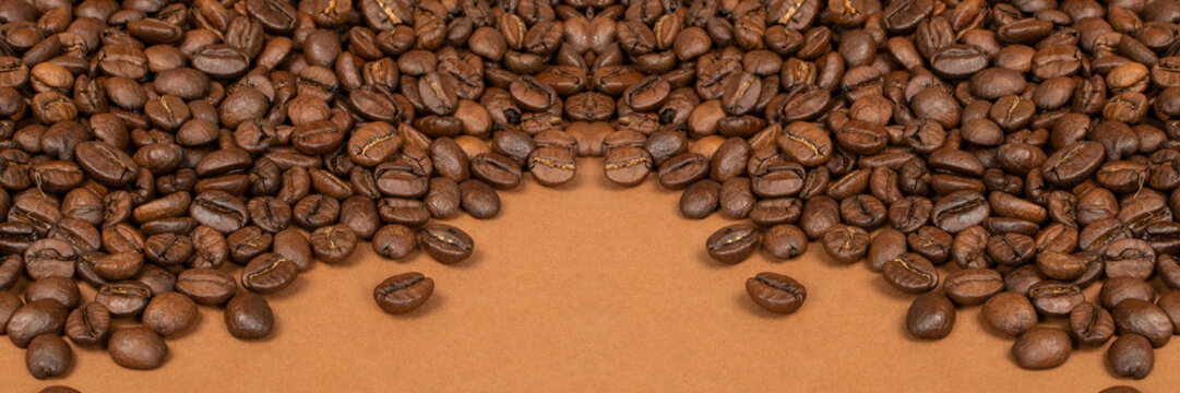 Dark brown whole coffee beans on wood background with copyspace