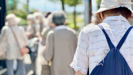 行列を作るたくさんの高齢女性の後姿