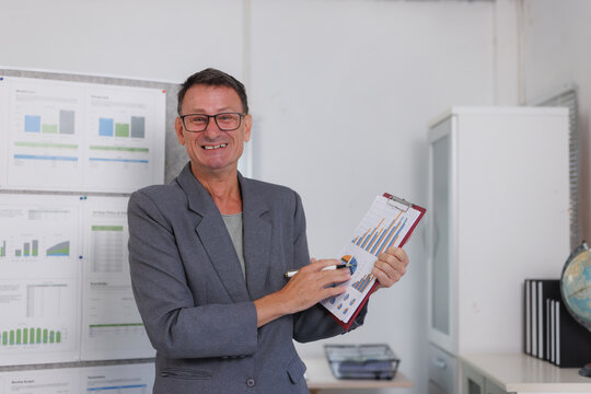 Mature businessman presenting financial data with clipboard