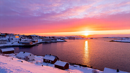 Snowy coastal town at sunset