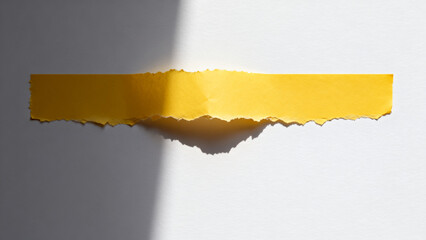 Torn yellow paper revealing shadow