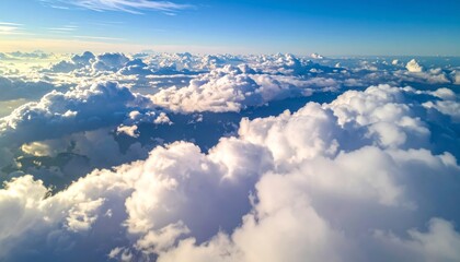 Fototapeta premium High white cumulus clouds drift over the blue mountain landscape in the clear day air
