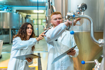 Engineers team inspecting industrial brewery machinery and equipment