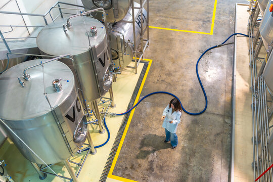Woman scientist working in modern beer factory - Powered by Adobe