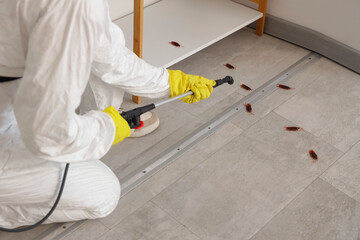Female pest control specialist carrying out cockroach disinfection in room