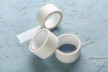 Rolls of white masking tape on blue grunge background