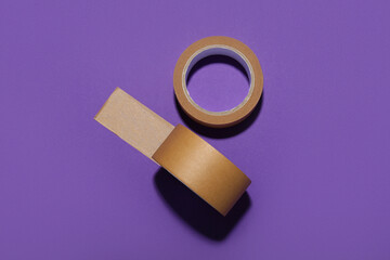 Rolls of brown masking tape on purple background