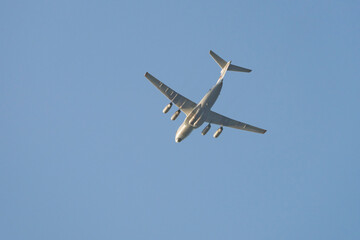 A large transport plane is flying in the sky on a sunny day