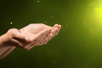 Female hands with energy sparkles and yellow light on black background