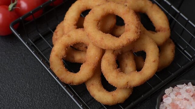Onion rings or fried squid in breadcrumbs with sauce, takeaway food. Onion rings fried, fast food as a background for your design