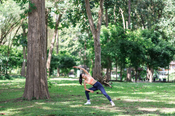 Young woman performing side lunge stretch in park
