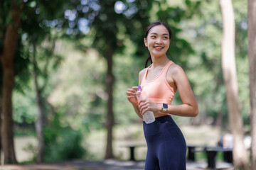Young asian woman smiling hydrating practicing wellness outdoor