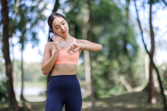 Woman checking fitness tracker during outdoor workout break