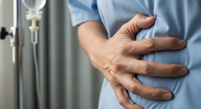 Patient experiencing severe abdominal pain holding stomach in hospital setting with IV drip.
