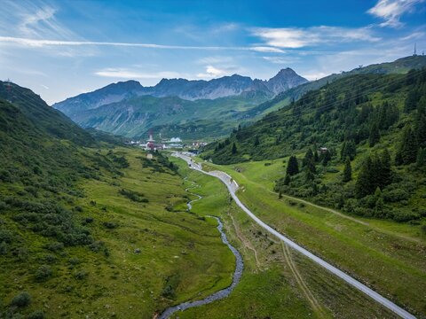 Austrian Alps landscape with a winding road and stream