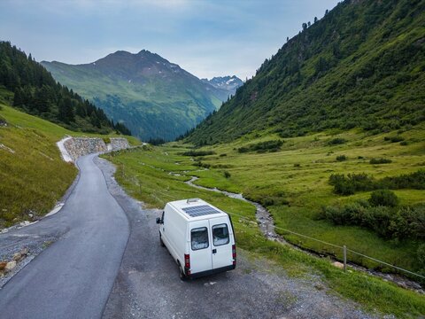 Camper van with solar panels traveling in the Austrian alps