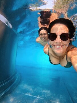 Couple smiling at the camera taking a selfie together underwater