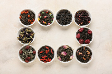 Bowls with different fruit tea on light grunge background