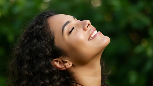 Young woman with curly hair tilting her head back with eyes closed