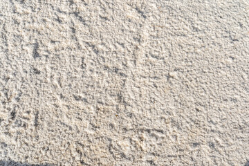 Close-up texture of natural salt surface with rough crystalline pattern.