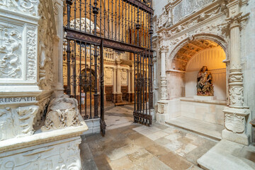 Ancient Gothic interior with stone sculpture and metal gate in Burgos Cathedral.