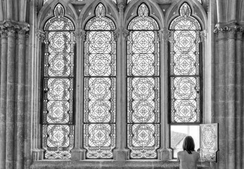 Monochrome photo of gothic architecture and human presence, spiritual stillness.