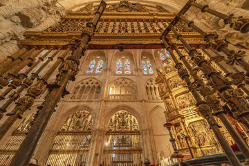 Ancient Gothic interior with stone sculpture and metal gate in Burgos Cathedral.