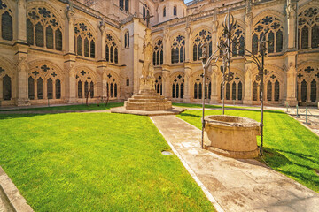 Historic courtyard with stone arches and Gothic windows in Burgos Cathedral.