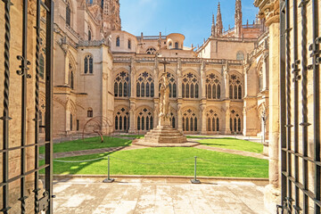Historic courtyard with stone arches and Gothic windows in Burgos Cathedral.