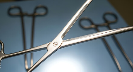 Close up of sterile stainless steel surgical forceps on a blue medical tray.