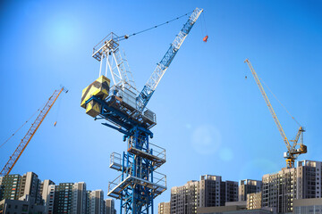 Tower cranes and apartments at construction sites
