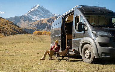 Enjoying serene moments in nature with a camper van near a mountain