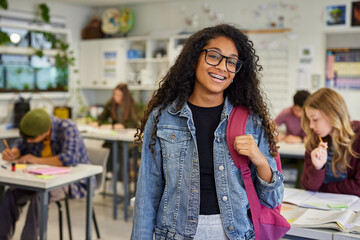 Multiethnic girl student standing in classroom with a big smile