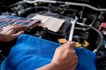 A young man works on fixing an engine by himself at home, showing DIY maintenance and mechanical skills.