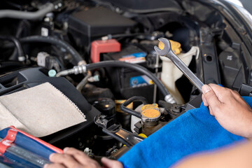 A young man works on fixing an engine by himself at home, showing DIY maintenance and mechanical skills.