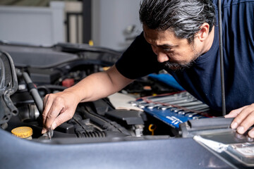 A young man works on fixing an engine by himself at home, showing DIY maintenance and mechanical skills.